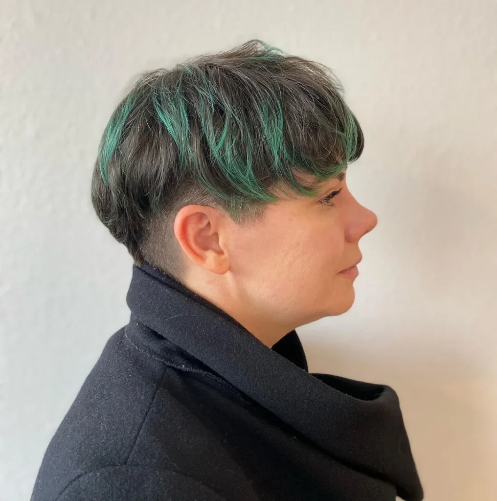 Pixie-Cut mit grünen Highlights und rasierten Seiten