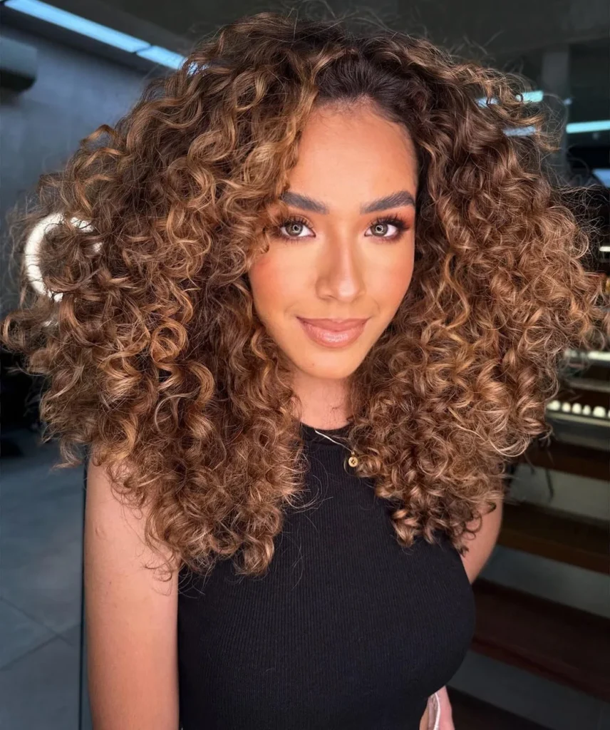  Brünette Locken mit karamellfarbenen Highlights