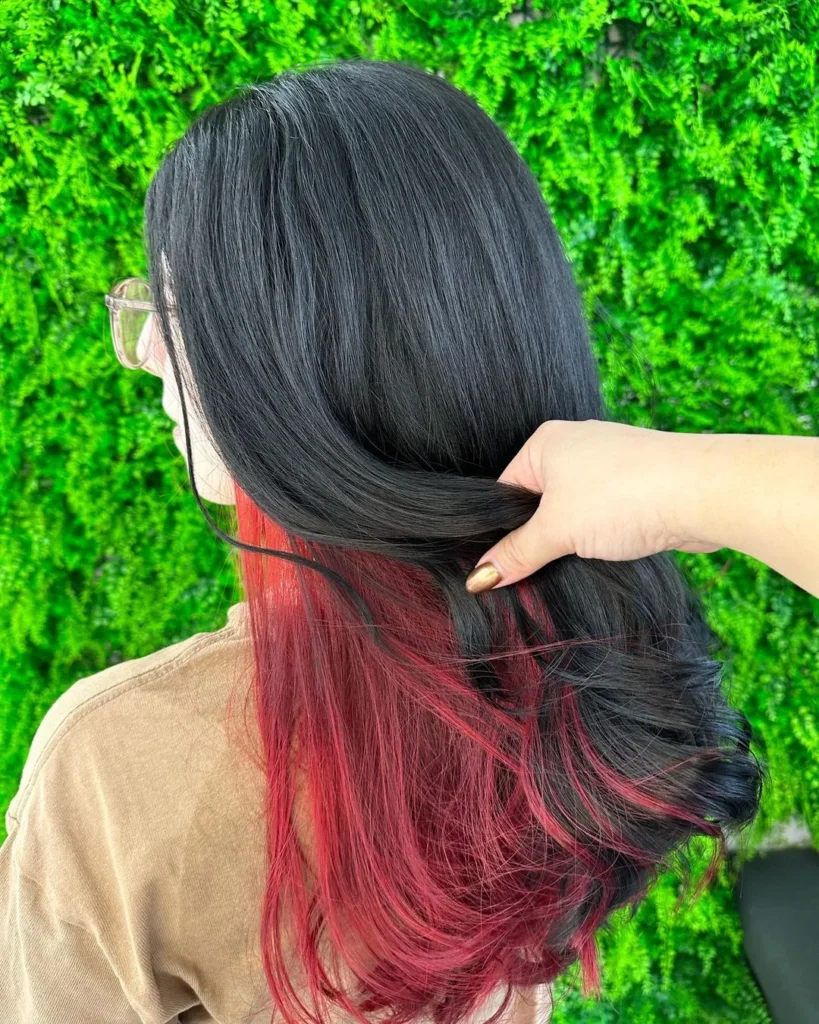 Schwarzes Haar mit innerem roten Balayage